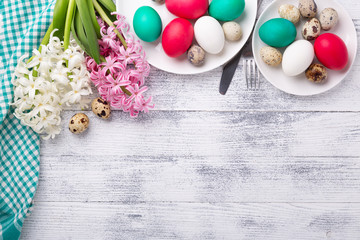 Obraz premium Easter composition. Bright easter eggs, pink and white hyacinth on wooden background. Copy space. Top view