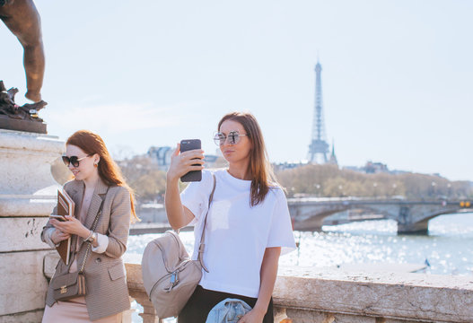 Two friends taking pictures on the Alexandre III bridge in Paris France
