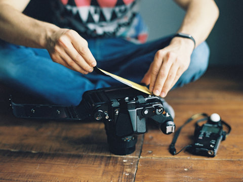 Crop man changing film in camera