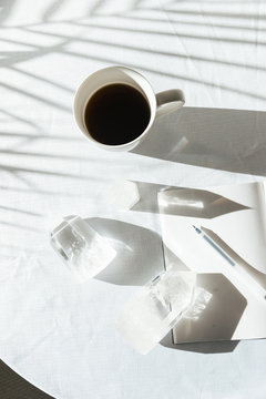 Crystals on table with coffee cup, pen, and notebook