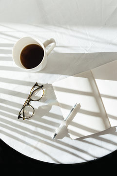 Still life of coffee cup, notebook and pen