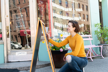 Restaurant worker writing specials on blackboard