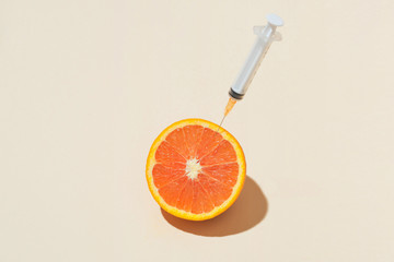 Products containing vitamin C. Oranges with a syringe