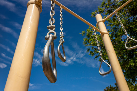 Close up of gymnastics rings at park on sunny day with blue sky
