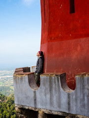 Joven feliz disfrutando desde la almena de un castillo en Portugal