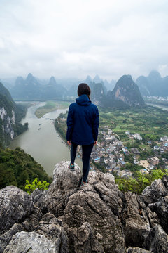 Traveller woman on hilltop on a scenic landscape