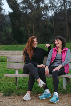 Mom and daughter hanging out together on park bench