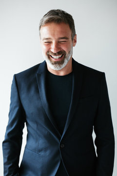 Portrait of a happy mature man wearing a cool black suit.