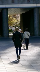Blond woman with sunglasses walking through city on chessboard ground, Osaka, Japan