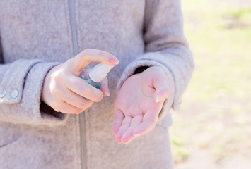 Woman's hands press a bottle with a disinfectant to her hands on the street. Macro shot and macro shot, Selective focus, Prevention by covid 19, Bacteria, healthcare concept