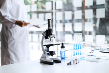 Biochemistry laboratory research, Chemist is analyzing sample in laboratory with Microscope equipment and science experiments glassware containing chemical liquid