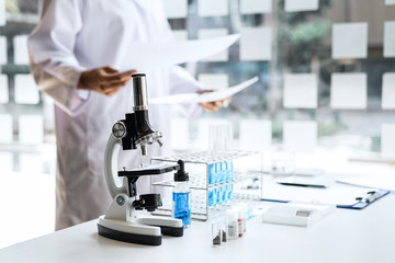 Biochemistry laboratory research, Chemist is analyzing sample in laboratory with Microscope equipment and science experiments glassware containing chemical liquid