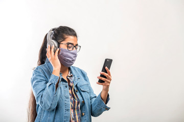 A teenager girl with mask enjoying music while quarantine during covid-19 pandemic