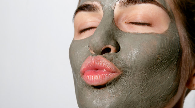 Young female relaxing with facial mask on