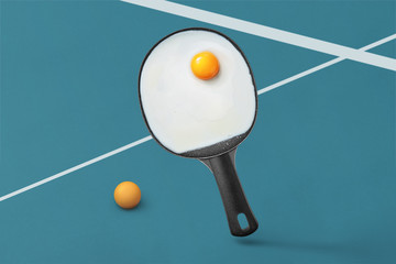 Ping-pong racket pan with egg yolk on a blue background with spa
