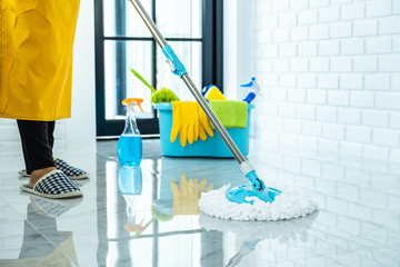 Wife housekeeping and cleaning concept, Happy young woman in blue rubber gloves wiping dust using mop while cleaning on floor at home