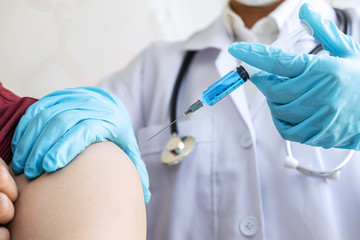 Doctor making injection vaccination patient to prevent pandemic of the disease