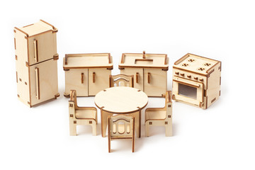 Toy miniature wooden kitchen furniture stands on a white background. Refrigerator, gas stove, sink...
