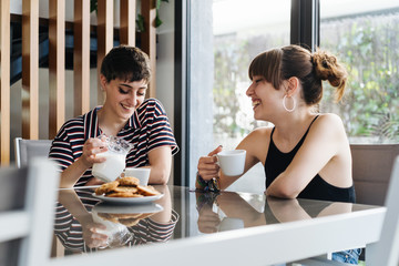 Girlfriends Smiling While Having A Coffee At Home.