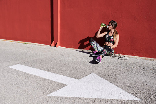 Sportswoman urban workout drink water.