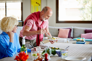 Senior man serving food for his wife