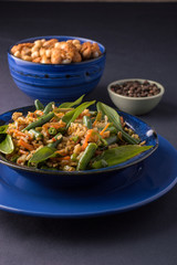 fried rice with vegetables in a blue plate.