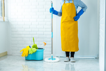 Housekeeping and cleaning concept, Happy young woman in blue rubber gloves wiping dust using mop...