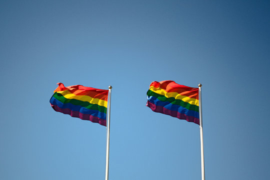Rainbow flags, LGBT flags against a blue sky background