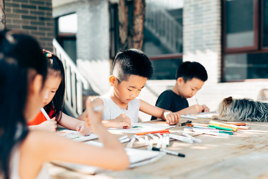 Kids drawing on a table outdoors
