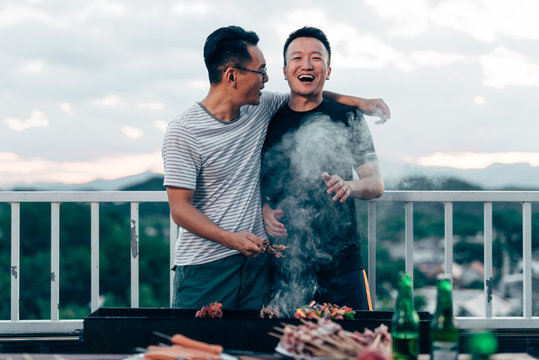Two friends embracing each other during backyard party on summer evening