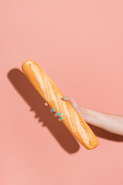 Hand holding a baguette.