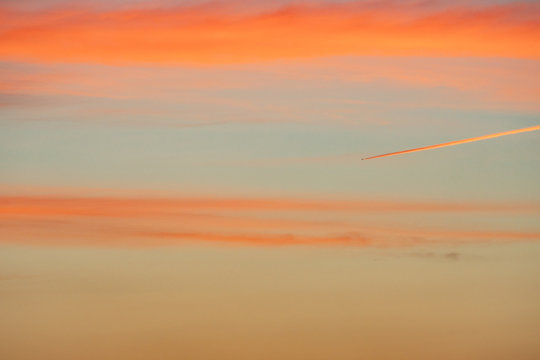 The Contrail with Clouds Beautifully Turning into Red Color - Powered by Adobe