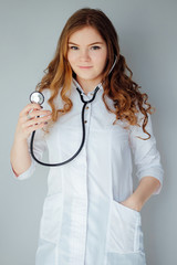 Young woman doctor in a white coat and medical mask. The medicine