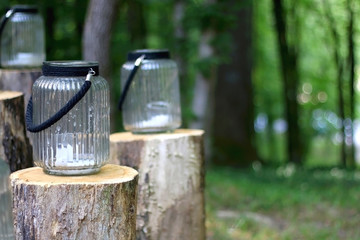 Candle holders outdoor in the woods. Rustic wedding decorations. Selective focus.