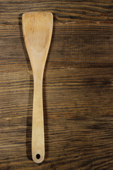 Beige wooden spatula on brown wooden table. Kitchen concept, cpace for text.