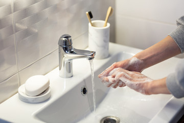 Washing hands rubbing with soap man for winter flu virus prevention, hygiene to stop spreading germs.