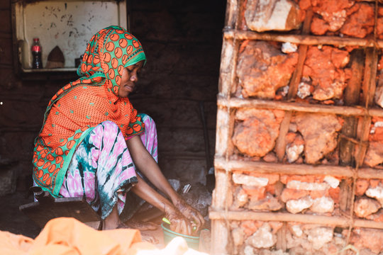 Beautiful woman seated on the floor washing the vegetables indoo