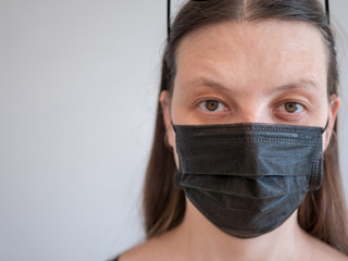 Adult woman in tightening corset in black protective mask and big glasses posing in front of camera. concept of protecting medical personnel from infections and viruses