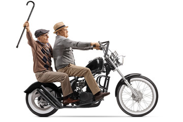Obraz na płótnie Canvas Two senior men riding on a custom chopper motorbike