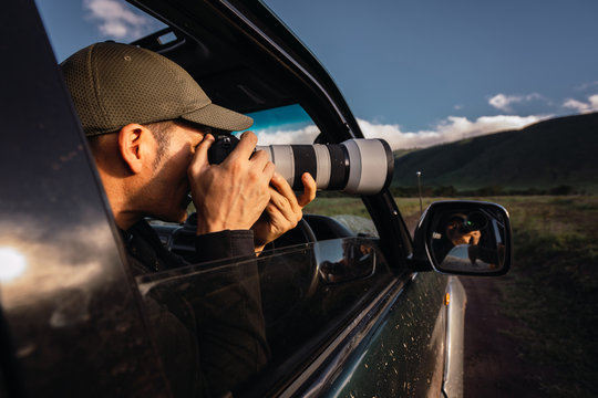 Man taking photos from he car window, safari day in Tanzania