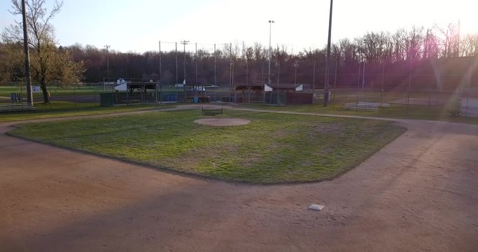 Drone baseball diamond in park at dusk move to home plate