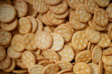 A lot of cookies with salt. Background from round crackers. Food yellow snack texture. Top view