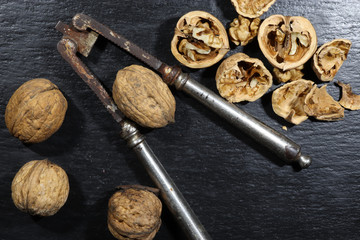 Photography of a very old nutcracker and walnuts on a slate for food background