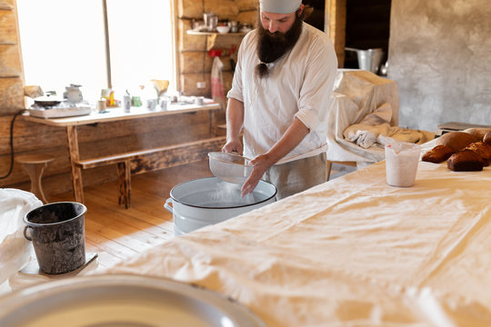 Man preparing bread dough in rural house