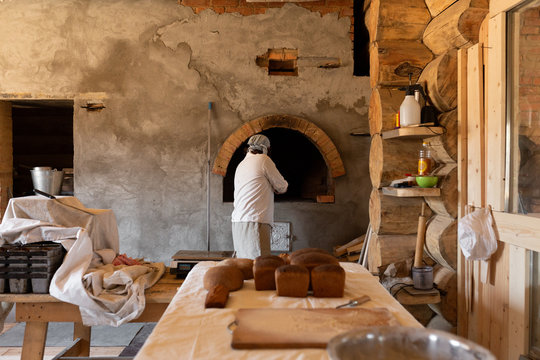 Man baking bread in masonry stove