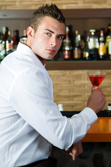 Beautiful man having a drink in a bar