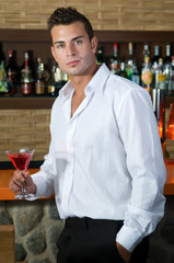 Beautiful man having a drink in a bar