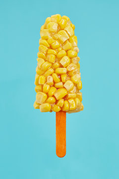 Popsicle made of sweetcorn against blue background