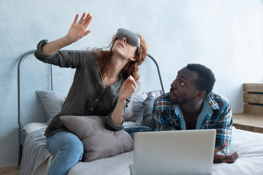 African man and red-haired woman having fun in glasses of virtual reality