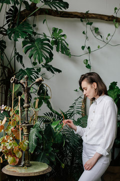 Young woman touching plant